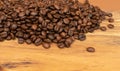 Dark brown whole coffee beans on wood background with copyspace