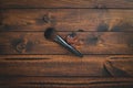 Brown wood background with single makeup brush and leaf.