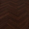 Dark brown wooden floor with a classic herringbone pattern. Rich, polished surface reflecting light Royalty Free Stock Photo