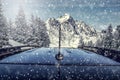 A dark car on heavy snowy road. Transportation on sunny day in winter time. Royalty Free Stock Photo