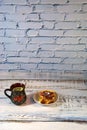 Dark ceramic tea cup with lemon and a plate with Viennese waffles and strawberry jam