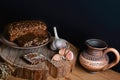 Dark cereal bread with sunflower seeds, cup of milk, garlic concept of healthy eating, on a wooden background on a stump, set