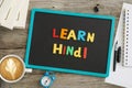 Dark chalkboard with Learn Hindi message from colourful plastic letters