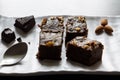 Dark Chocolate almond brownies served on a white ceramic plate with dark wooden background.