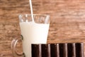 Dark chocolate bar, glass of milk and mint leaves on a wooden table Royalty Free Stock Photo