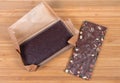 Dark chocolate bar in open paper wrapper, chocolate with nuts