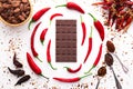 Dark chocolate bar, red hot chilli pepper cayenne, dry hot chili spices, cocoa beans nibs powder, food tasty design on black Royalty Free Stock Photo