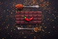 Dark chocolate bar, red hot chilli pepper cayenne, dry hot chili spices, cocoa beans nibs powder, food tasty design on black Royalty Free Stock Photo