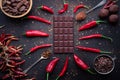 Dark chocolate bar, red hot chilli pepper cayenne, dry hot chili spices, cocoa beans nibs powder, food tasty design on black Royalty Free Stock Photo