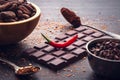 Dark chocolate bar, red hot chilli pepper cayenne, dry hot chili spices, cocoa beans nibs powder, food tasty design on black Royalty Free Stock Photo