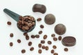 Dark chocolate candies,sweets with a spoon of coffee beans on light background. Lifestyle concept