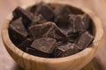 Dark chocolate chunks in wood bowl on table