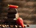 Dark chocolate, fresh strawberries, assortment flavor nuts on a dark background