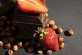 Dark chocolate, fresh strawberries, sweet assortment flavor nuts on a dark background
