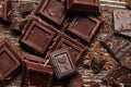 Dark chocolate pieces and bar on a brown table. Top view. Royalty Free Stock Photo