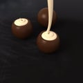 Dark chocolate pralines with vanilla cream filling on blackboard