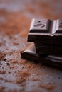 Dark chocolate stack with cocoa powder on a stone background Royalty Free Stock Photo