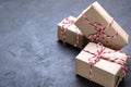 Dark Christmas background . Brown kraft paper parcel tied with red and white string on black Royalty Free Stock Photo