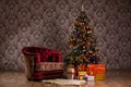 Dark Christmas scene with a decorated Christmas tree, gifts and armchair Royalty Free Stock Photo