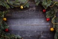 Dark Christmas table background with Christmas tree branches and red and gold bauble decoration. Border composition Royalty Free Stock Photo