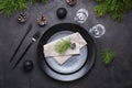 Dark christmas table setting design. Black plates, champagne glasses, fork and knife set with napkin, fir branch Royalty Free Stock Photo