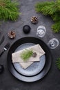 Dark christmas table setting design. Black plates, champagne glasses, fork and knife set with napkin, fir branch Royalty Free Stock Photo