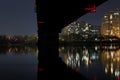 Dark cityscape with bridge above calm