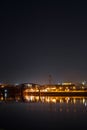 Dark cityscape with buildings, lights, river