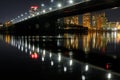 Dark cityscape with illuminated bridge and