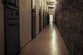 Dark claustrophobic corridor and locked cell doors in a prison. Deprivation of liberty, An open door at the end of the corrido Royalty Free Stock Photo