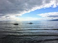 A dark cloud moving in with bad weather blocking off the sunny blue sky over the ocean Royalty Free Stock Photo