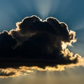 Dark cloud with a radiant silver lining against a deep blue sky. Sun rays illuminate the Royalty Free Stock Photo