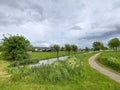 Dark clouds above the Groene Zoom between Capelle and Nieuwerkerk with grass, abondoned greenhouse and animals