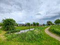 Dark clouds above the Groene Zoom between Capelle and Nieuwerkerk with grass, abondoned greenhouse and animals