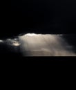 Dark clouds over the coastline and ocean with ray lights
