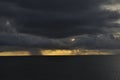 Dark clouds with rain on the ocean during sunset. Seychelles