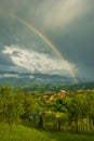 Dark Clouds and Rainbow Standing above a Mountain Village Royalty Free Stock Photo