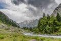 Dark clouds and river down stream view of green valley Royalty Free Stock Photo