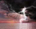 Dark cloudy sky with lightning striking sea. Picturesque thunderstorm Royalty Free Stock Photo