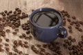 Dark Coffee in Blue Cup Surrounded by Coffee Beans Royalty Free Stock Photo