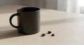 Dark coffee mug with scattered coffee beans on a light surface Royalty Free Stock Photo