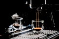 Dark coffee pouring in a transparent glass espresso cup from a manual espresso machine, with copy space, close up