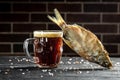 Dark cold beer in a frosty mug on dark wooden table. Lager beer glasses and snacks dry fish, banner, menu, recipe place for text Royalty Free Stock Photo