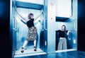 Dark color toned picture of two fashionable girl in the elevator. Royalty Free Stock Photo