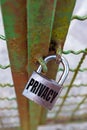 Dark-colored padlock, with `privacy` writing, which closes a green gate