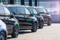 Dark colored passenger vans in a parking lot