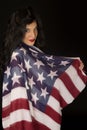 Dark complected woman with American flag draped over shoulder