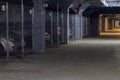 Dark coridor in underground parking garage with separate boxes, view on the way out Royalty Free Stock Photo