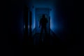 Dark corridor with cabinet doors and lights with silhouette of spooky horror man standing with different poses. Royalty Free Stock Photo