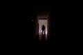 Dark corridor with cabinet doors and lights with silhouette of spooky horror man standing with different poses. Royalty Free Stock Photo